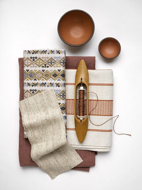 Collection of woven fabrics with weaving tools.