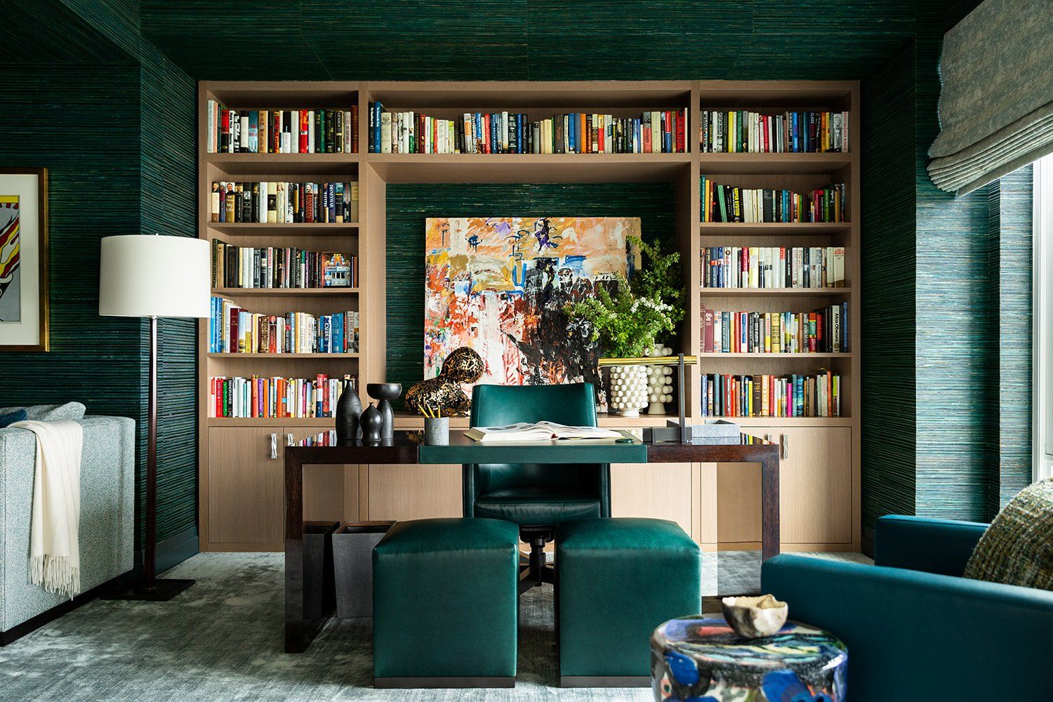 Elegant home office with textured wallcovering, built-in bookcase and sleek desk and seating.