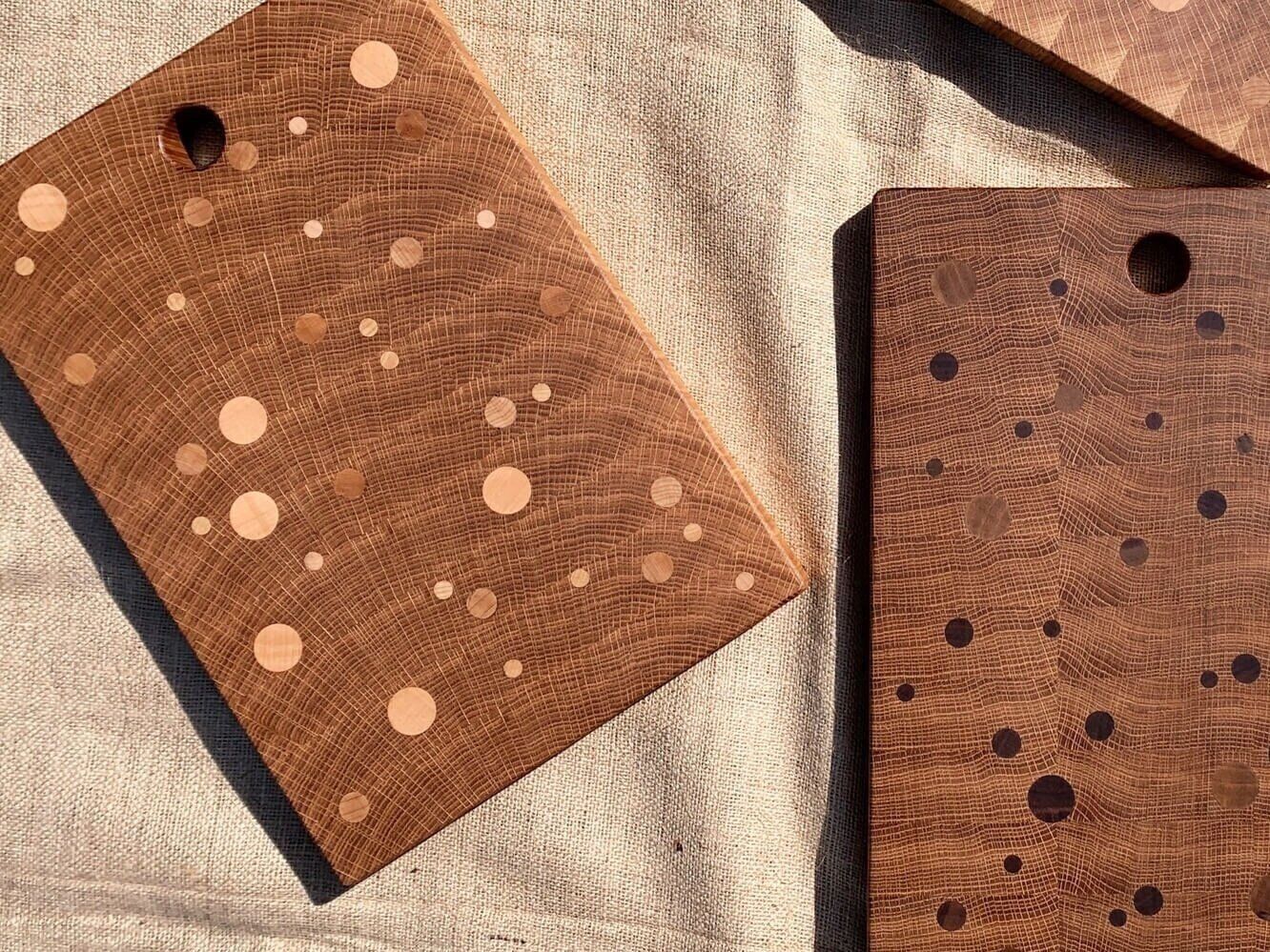 Inlaid wood cutting boards with patterns that resemble planets in space.
