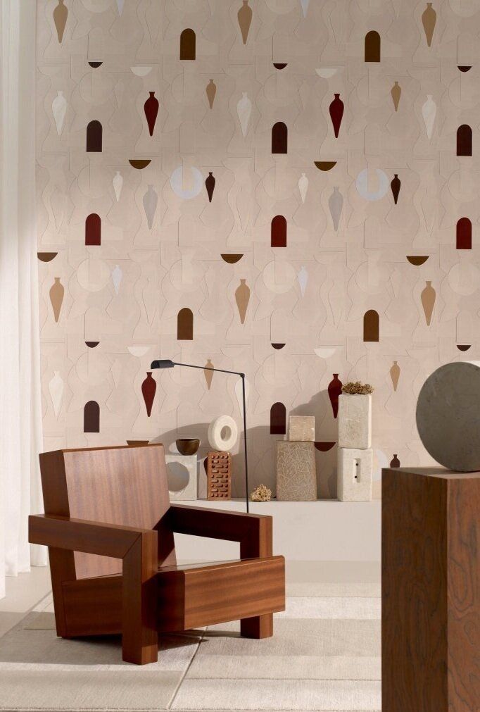 Patterned wallcovering behind stacked items and a wood chair.
