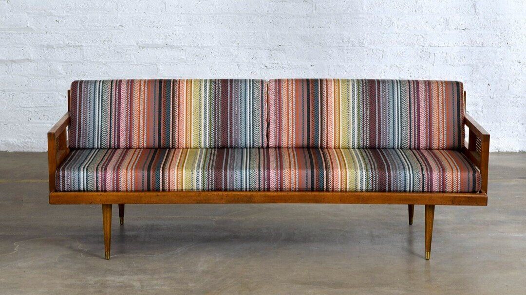 Modern bench style couch with striped fabric on upholstery.