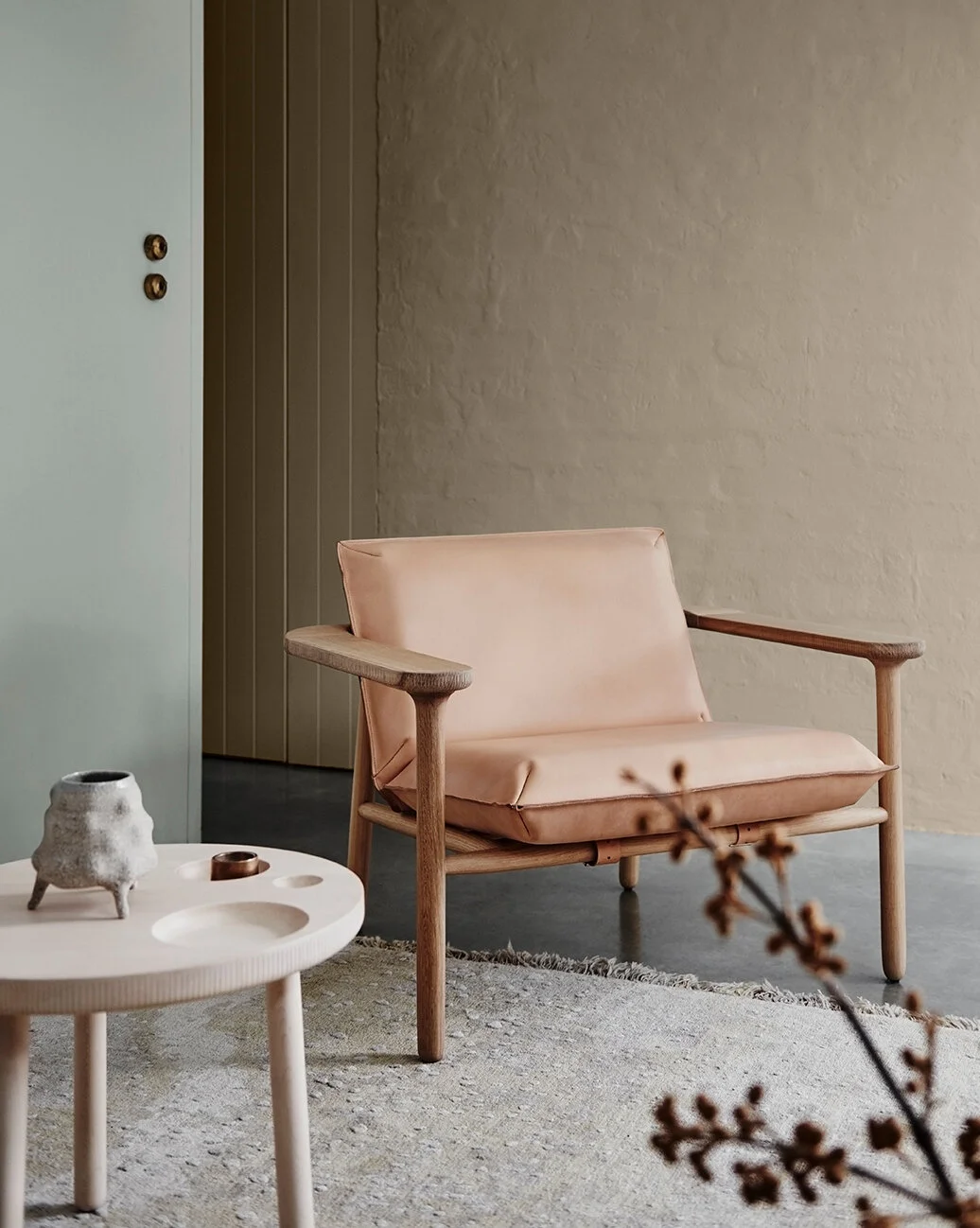Casual Southwest style seating area with carved wood chair with upholstered seating and side table with insets.