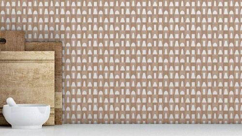 Repeating pattern wallcovering behind a stack of cutting boards and mortar and pestle.