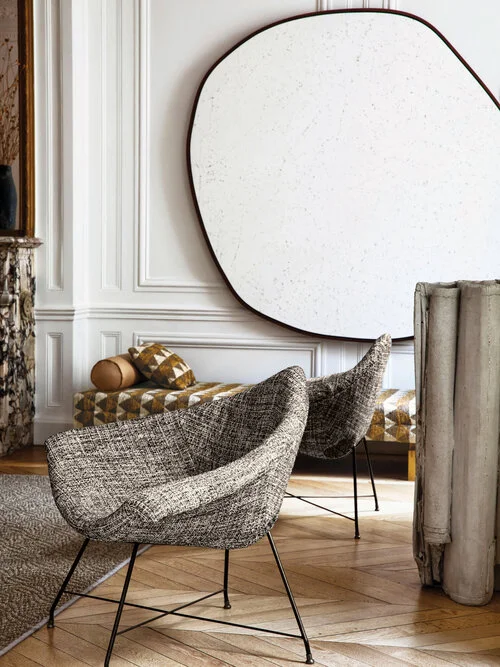 Modern living room with metal stick legged chairs and curved upholstered seats.