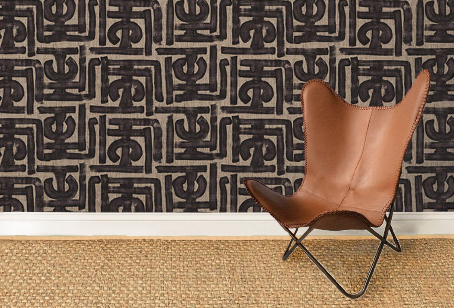 Leather sling chair on a sisal rug with a handpainted fabric wallcovering behind.