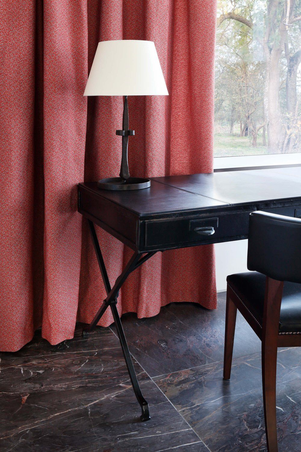 Draped window behind desk.