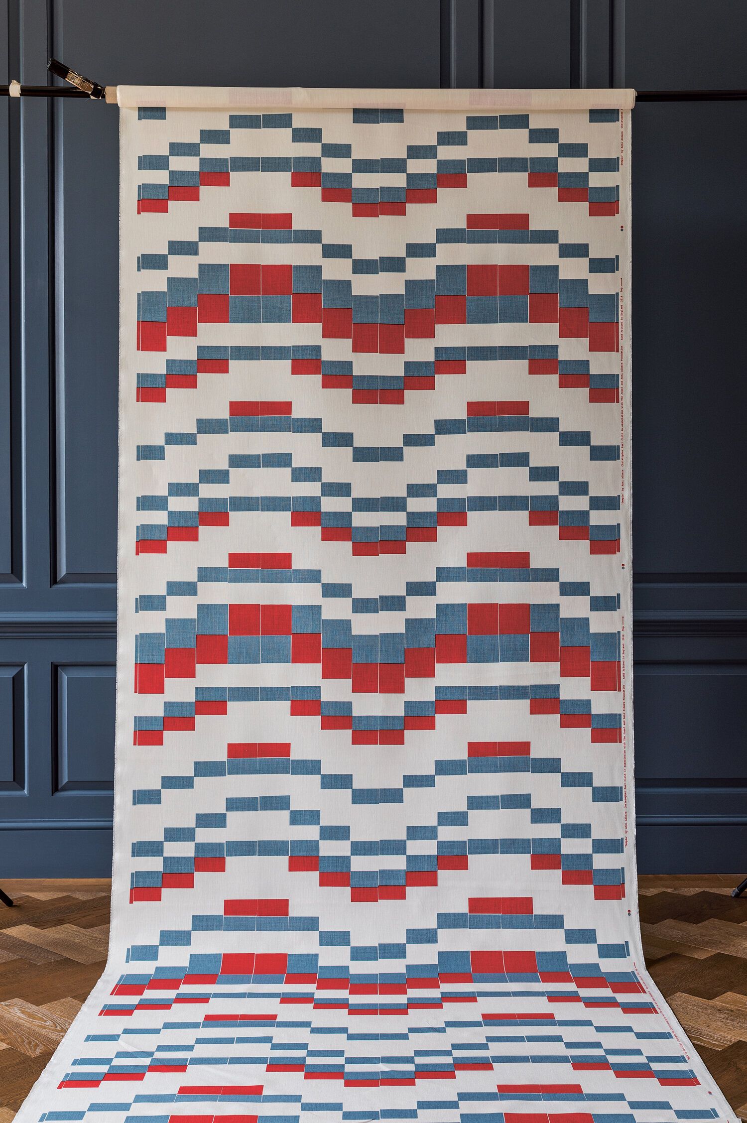 Patterned fabric hanging from a rod.