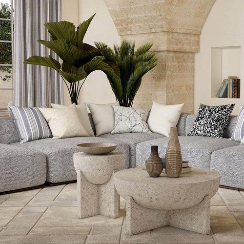 Modern upscale seating area with a stone support in background and stone tables in foreground.