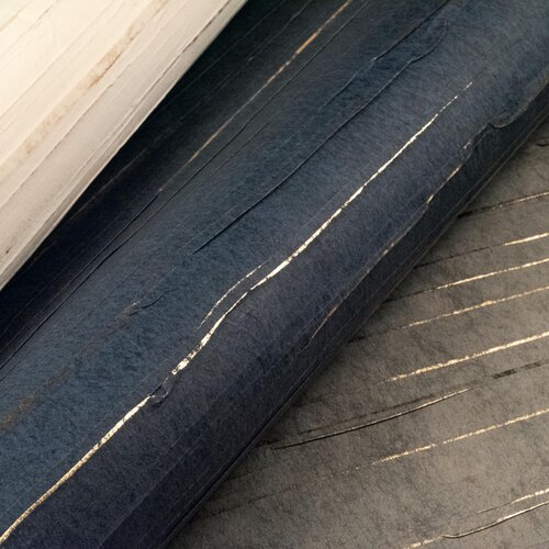 Rolls of slubbed fabric wallcovering with metallic threads woven through.