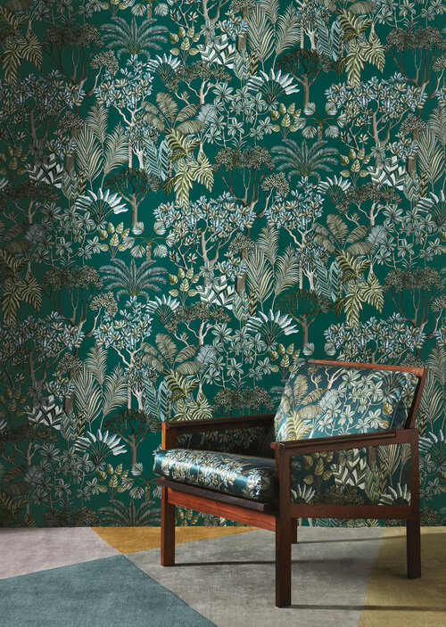 Ebullient wallpaper with pattern of boughs of leaves and matching fabric on side chair.