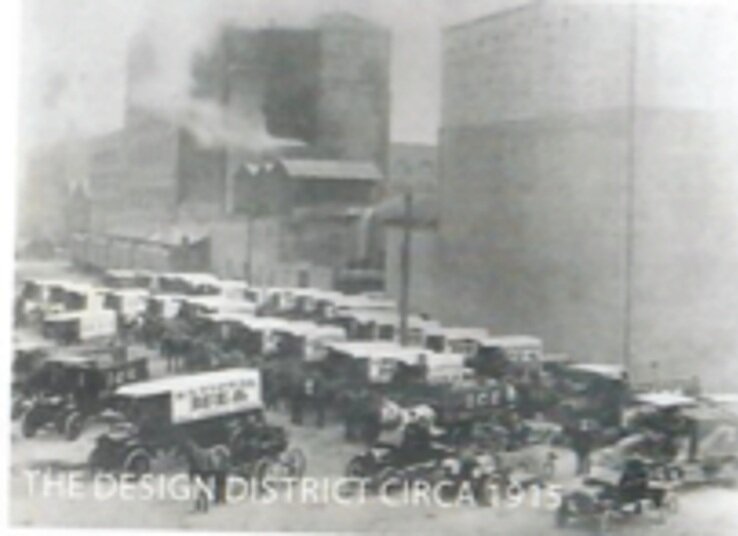 Slightly blurry black and white image with delivery trucks and horse-drawn wagons. The words 