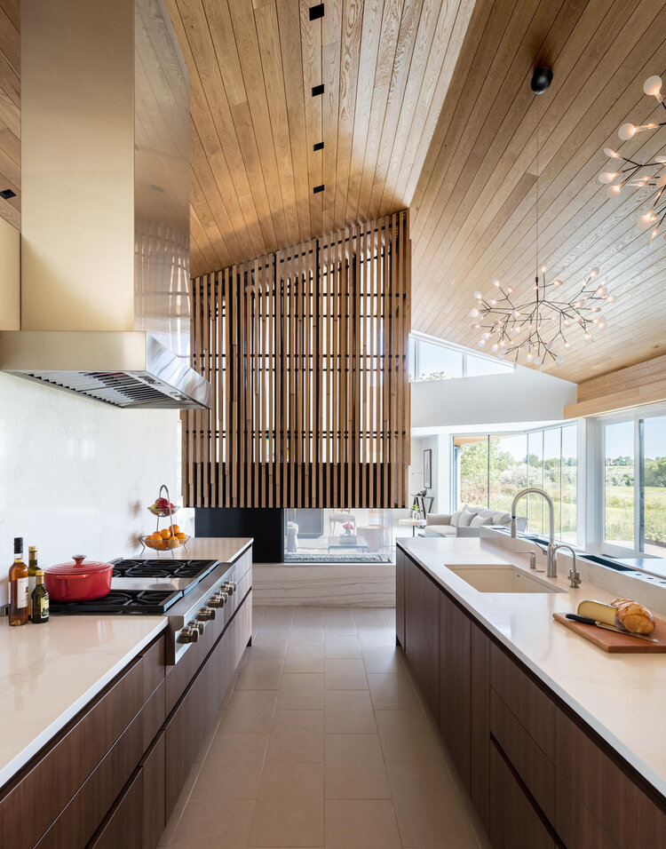 Modern kitchen with Scandinavian style wood front cabinets, oak ceiling and other wood and metal elements.
