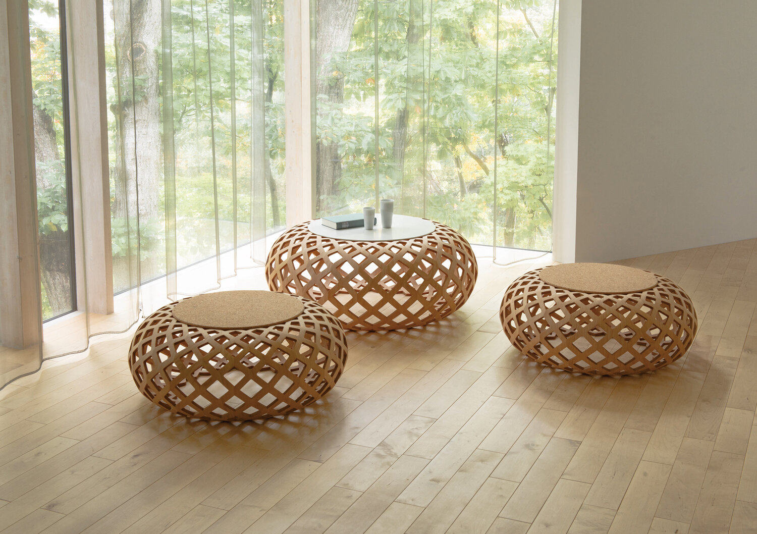 Three round cocktail tables with the appearance of woven bases and cork tops.
