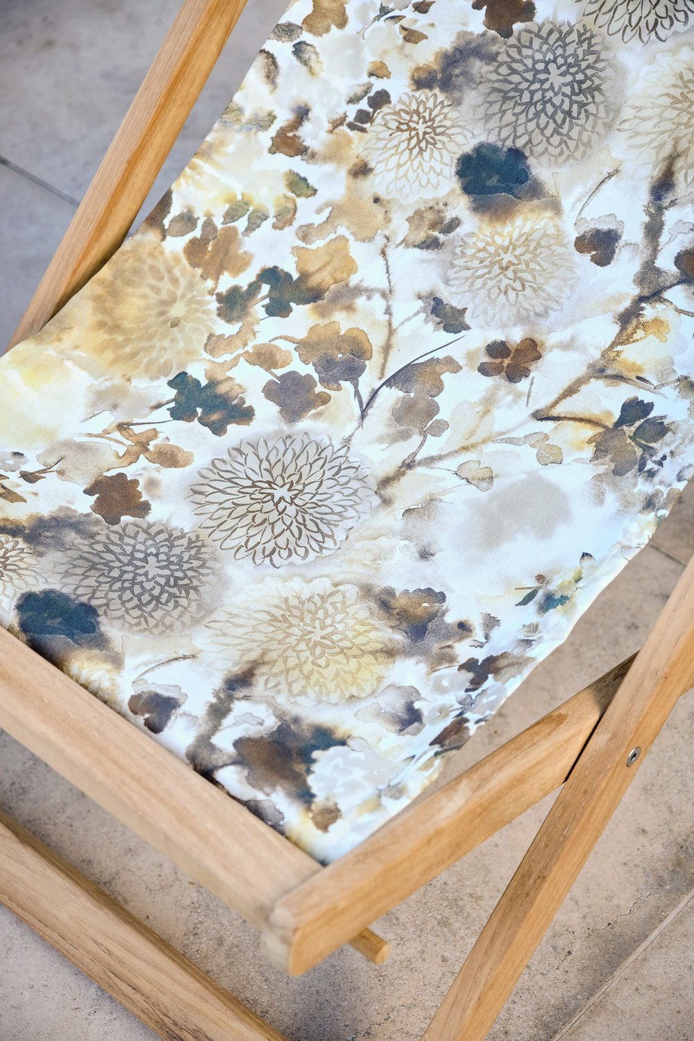 Closeup of floral fabric seat on a folding chair.