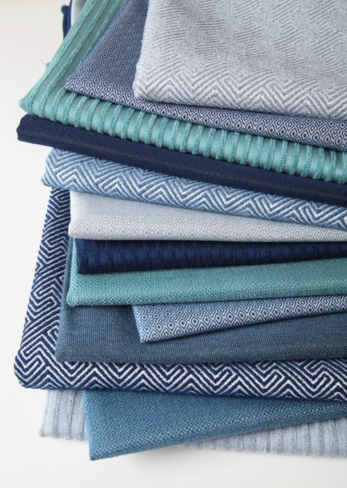 Stack of woven fabric swatches in shades of blue.