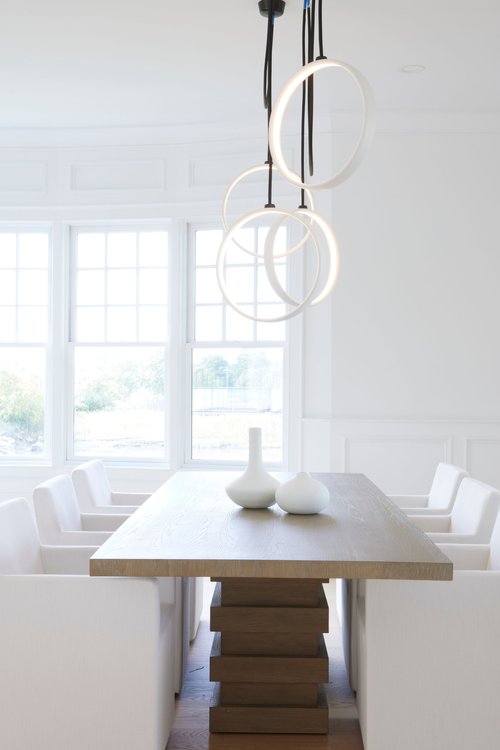 Hanging circular sculptural element over a dining table.