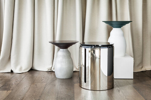 Pedestal circular small tables with mirrored tops.