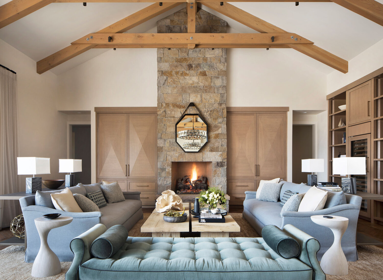 Formal living room with open beam ceiling and stone fireplace.