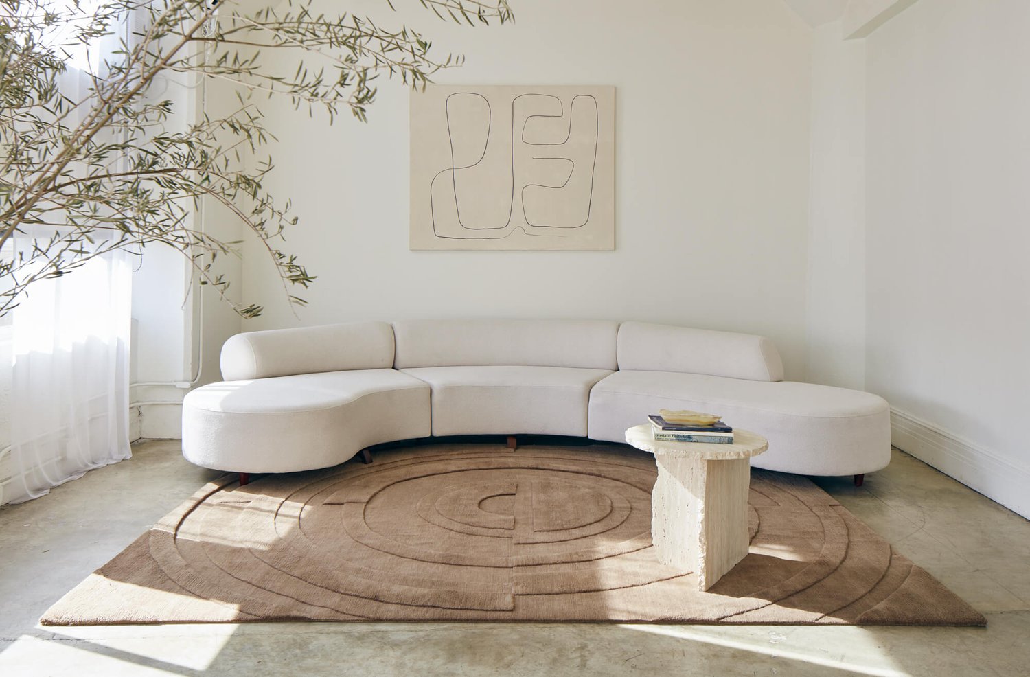 Very minimal and modern living room with a sculpted rug of a maze.