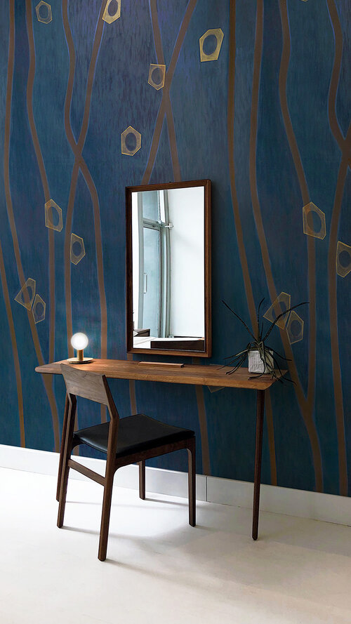 Graphic wallpaper as backdrop behind simple desk and chair.