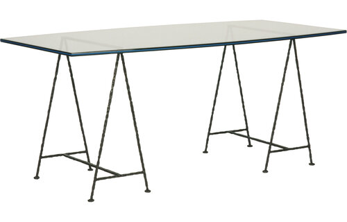 Glass topped desk with two sets of tripod legs in metal.