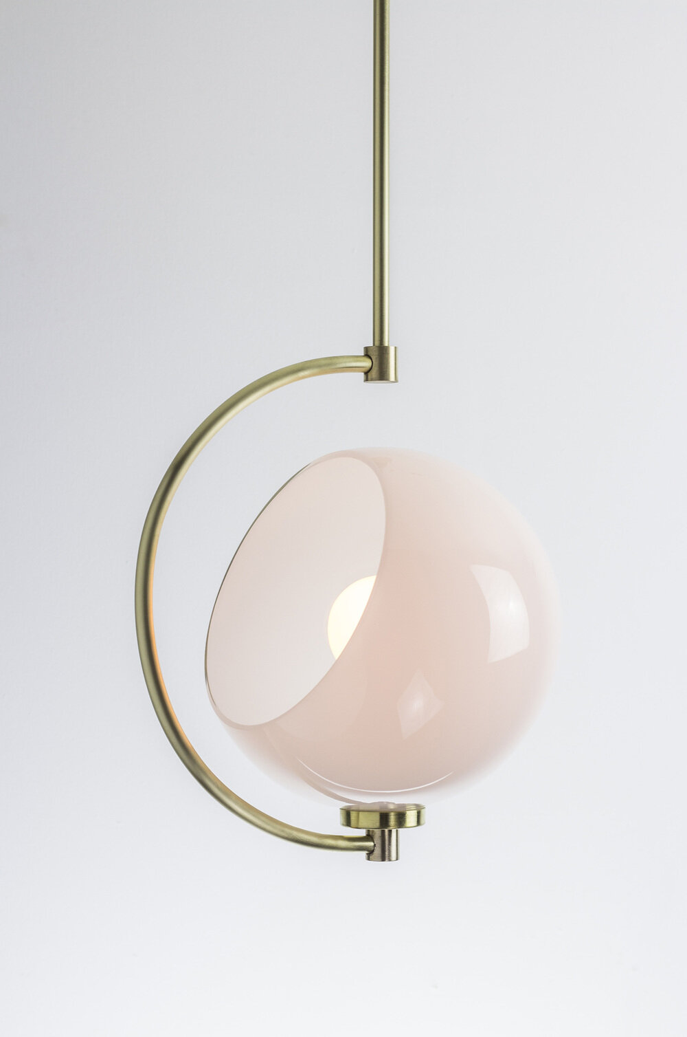 Pendant lamp with brass holder and cutaway glass globe.